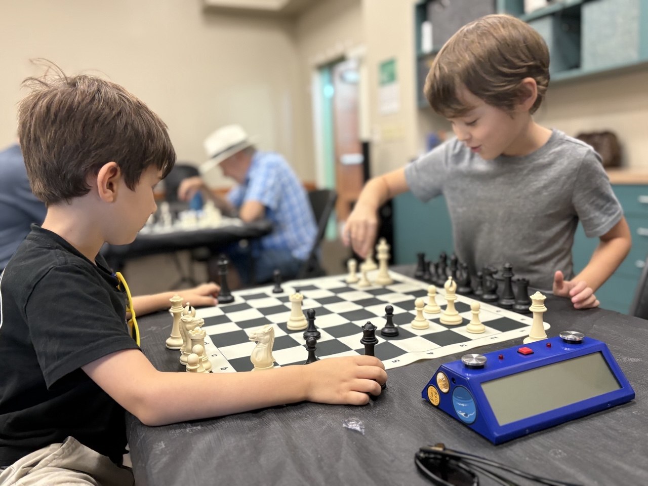 Keith playing at chess club with a blue clock.